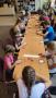 Na zdjęciu dzieci siedzące przy stolikach i grają w grę planszową.