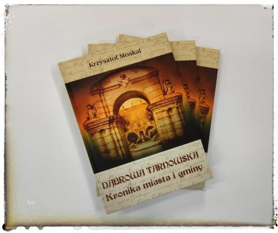 Trzy książki, widoczna okładka dr Krzysztof Moskal „Dąbrowa Tarnowska. Kronika Miasta i Gminy” 