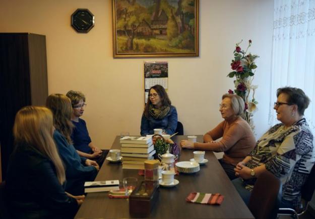 Sześć kobiet siedzi przy stole i rozmawia