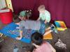 Dzieci wykonują prace plastyczne z kolorowych kartonów.