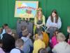Na zdjęciu Pani Wiosna wraz z młodą dziewczyną, czytają książkę przedszkolakom.